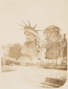 [Head of the Statue of Liberty on display in a park in Paris.]
