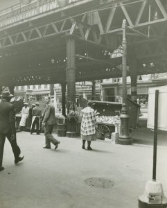 Pushcart vendors under the 8th Avenue elevated train at West 145th Street, Harlem, May 8, 1939.