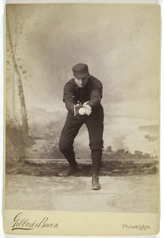 [Unidentified baseball player in dark uniform - catching form.]