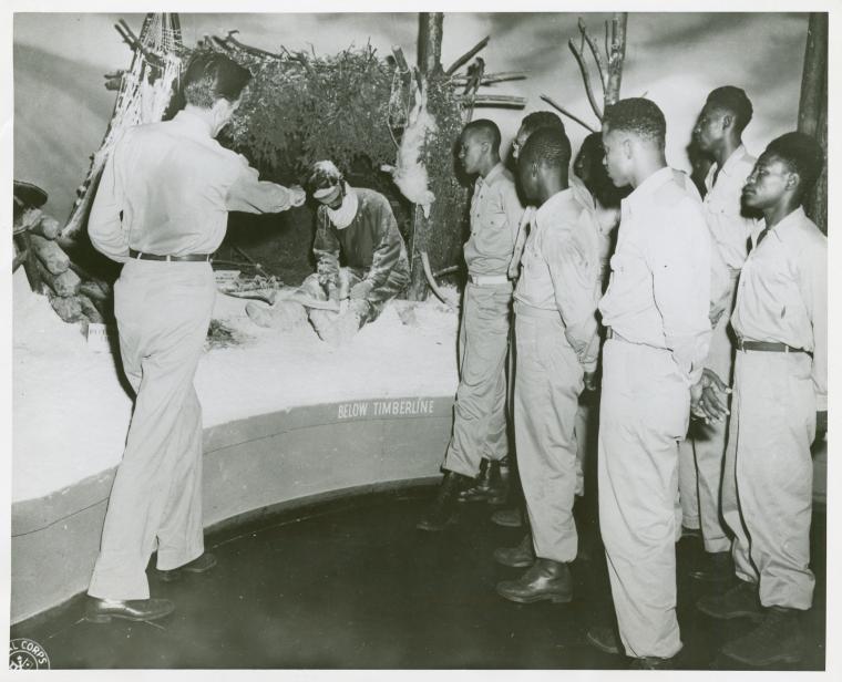 [Man pointing to a "Survival Museum" diorama of a soldier sitting under a makeshift bunker in the snow, while African American soldiers from the 25th Regimental Combat Team look on, Pensacola Naval Air Station, Florida, August 7, 1946.],Soldiers of the 25th Regimental Combat Team., Digital ID 1260297, New York Public Library