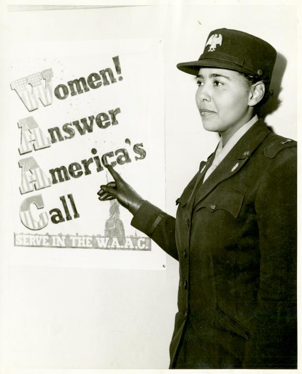 [African American Charity Adams, First Officer in the Women's Army Auxiliary Corps, standing in uniform and pointing to a poster that reads, "Women! Answer America's Call / Serve in the W.A.A.C.," February 24, 1943.],[African American Charity Adams, First Officer in the Women's Army Auxiliary Corps, standing in uniform and pointing to a poster that reads, "Women! Answer America's Call / Serve in the W.A.A.C."],Captain in the WAAC, Digital ID 1260343, New York Public Library