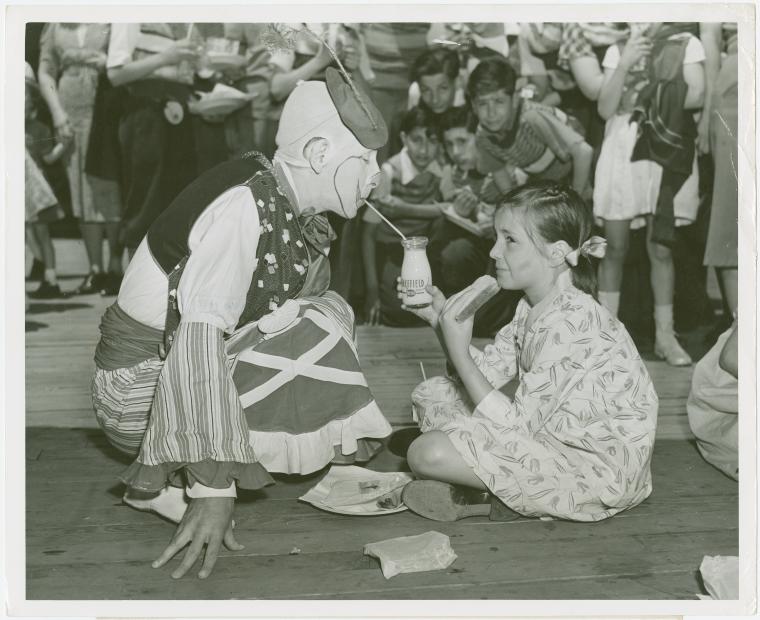 Amusements - Midway Activities - Girl sharing milk with clown, Digital ID 1653104, New York Public Library