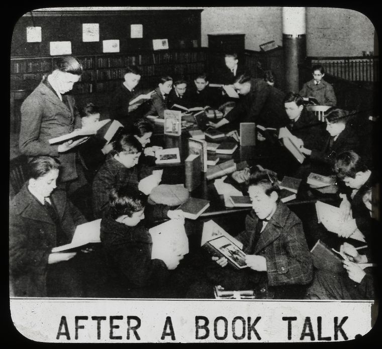  after a book talk, showing boys gathered around table reading, ca. 1920s., Digital ID 465282, New York Public Library