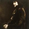 Seated woman wearing fur-trimmed coat and hat
