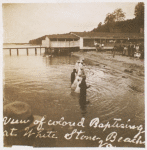 Postcard of adult men and women being baptized at the water's edge.