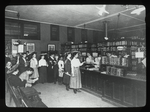 Aguilar, E. Broadway Branch, F.C.L.L., showing people lined up at charging desk, stacks protected by wire enclosure