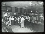 Aguilar, E. Broadway Branch, F.C.L.L., showing people lined up at charging desk, stacks protected by wire enclosure