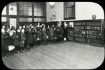 Rivington Street, line waiting for easy books, 1923: Librarian holds up book and those who want it raise their hands
