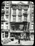 Rivington Street, neighborhood Guild Library, 26 Delancey Street, in two windows to left of fire escape, 3rd floor