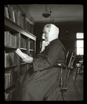 Webster: Interior views, Bohemian reader, woman in long dark dress, white scarf
