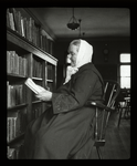 Webster: Interior views, Bohemian reader, woman in long dark dress, white scarf