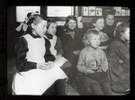 Webster: Interior views, Bohemian story hour, children listening to assistant telling story in native language