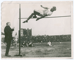 Harold M. Osborn clearing the bar in the running high jump.