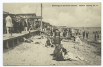 Bathing at Graham Beach, Staten Island, N.Y.  [people on sand with boardwalk and restaurant.]