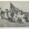 Midland Beach Staten Island. [people in old-fashioned garb on sand holding large American flag as well as small flags.]