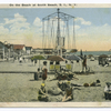 On the Beach at South Beach, Staten Island, N.Y.  [people on beach with buildings in background and swinging chairs amusement ride.]