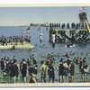 Harris'sBathing Slide South Beach, Staten Island. [people wading at shoreline, people on float and on giant water slide, Hoffman Island military base in background]
