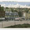 Tompkinsville, Staten Island, N.Y.  [interesting view of shopping area from high ground, trolley tracks on brick street, horse and wagon, striped awning over corner store]