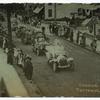 Carnival Parade, Tottenville, N.Y. [people on sidewalk watching parade of decorated old cars.]