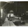 Interior view of lumber mill showing what is called the ninth stage in lumbering in that region, Snoqualmie National Forest, Wash. The men to the left are the "setter" and his helper. They handle the log while it is being sawed. The man near the center is the "sawer." On the extreme right is the "pondman" who tends to getting the logs from the pond to the mill. In the rear are seen the "off bearer," "edger man," "cuff off" and other laborers.