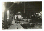 Interior view of lumber mill showing what is called the ninth stage in lumbering in that region, Snoqualmie National Forest, Wash. The men to the left are the "setter" and his helper. They handle the log while it is being sawed. The man near the center is the "sawer." On the extreme right is the "pondman" who tends to getting the logs from the pond to the mill. In the rear are seen the "off bearer," "edger man," "cuff off" and other laborers.