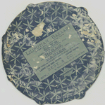 A trade card depicting a girl's face framed by a tambourine with painted flowers.