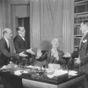 Arthur Byron (seated) as Nordson, with members of the Executive Committee: J.P. Wilson (as Mr. Osso), George Fogle (as Mr. Ciring) and Harold Thomas (as Dr. Wolff).