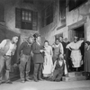 Scene in Catfish Row. Frank Wilson as Porgy (on knees by steps),  Evelyn Ellis as Bess (extreme right).