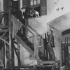 Scene from "Porgy" (1927). Set designed by Cleon Throckmorton. Georgette Harvey as Maria (left in the window). [Two policemen: Hugh Rennie and Maurice McRae]