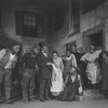 Scene in Catfish Row. Frank Wilson (Porgy, knees by steps), Georgette Harvey (Maria, in the door), Evelyn Ellis (Bess, extreme right), Wesley Hill (Jack, second from left).