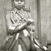 Kru woman with " shield " finger rings and hair ornaments.