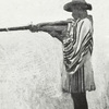 A Gora man firing gun from armpit.