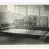 Before and after baking. This shows the dough ready to be baked and the finished product in the rear. A rack of bread dough ready to be placed in oven shown in the R. foreground. One of these ovens including top and bottom holds 288 loves. Cote d'Or..