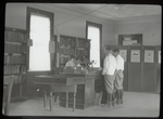 Williamsbridge, Two boys standing at desk where librarian is seated and writing, Sub-branch
