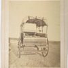 Howard ambulance, rear view, tailgate partially lowered, rollers that support cushioned litters are visible. Background masked.