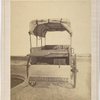 Howard ambulance, rear view, tailgate down, with litters, water tank with spigot underneath. Background masked.