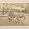 Howard ambulance, rear and side view, tailgate up, on city street.