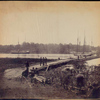 Pontoon bridge across the James [Men sitting and standing in foreground, ships at anchor in river] / Alexander Gardner