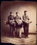 Lifting a wounded or sick soldier [Three soldiers carry a fourth to demonstrate one stage of the correct method to raise a soldier from a reclining position for carrying]