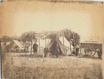 [Four men in front of sheltered tent next to U.S. Christian Commission wagon, another tent at rear left.] / Alexander Gardner
