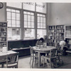 Seated reader and reader at bookshelves, Donnell-Nathan Strauss
