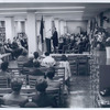 White-haired man behind speaker, Morris Hadley, Trustee