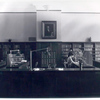 Librarian at desk and reader at bookshelves]