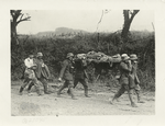 The American advance in the Argonne. German prisoners carrying German wounded to American dressing stations behind the lines in the Argonne. The two men walking in the rear are slightly wounded.