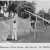 Mending nets along the beach, St. Kitts.