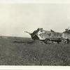 Large Am. tank which was wrecked by a direct hit from the German artillery just as it had reached a machine gun nest on the heights in front of Madeleine Ferme. In the foreground are the graves of the crew and in the background is a small tank that was wrecked. Near Madeleine Ferme, between Nautillois and Cunel, Meuse. Nov. 10, 1918.
