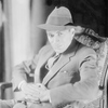 Portrait of Jed Harris (in hat, seated in armchair).