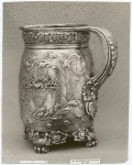 Silver mug decorated with foliage.