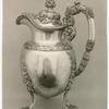 Silver pitcher decorated with grapes and leaves.