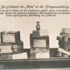 Die Goldbeute der Möwe in der Kriegsausstellung. Links 3 von den 14 Kisten, die mit Goldbarren gefüllt warren, in der Mitte eine der beiden Kisten, die Goldstaub enthielten, oben Probeflasche mit Goldstaub, rechts originalgetreue Nachbildung der Goldbarren.